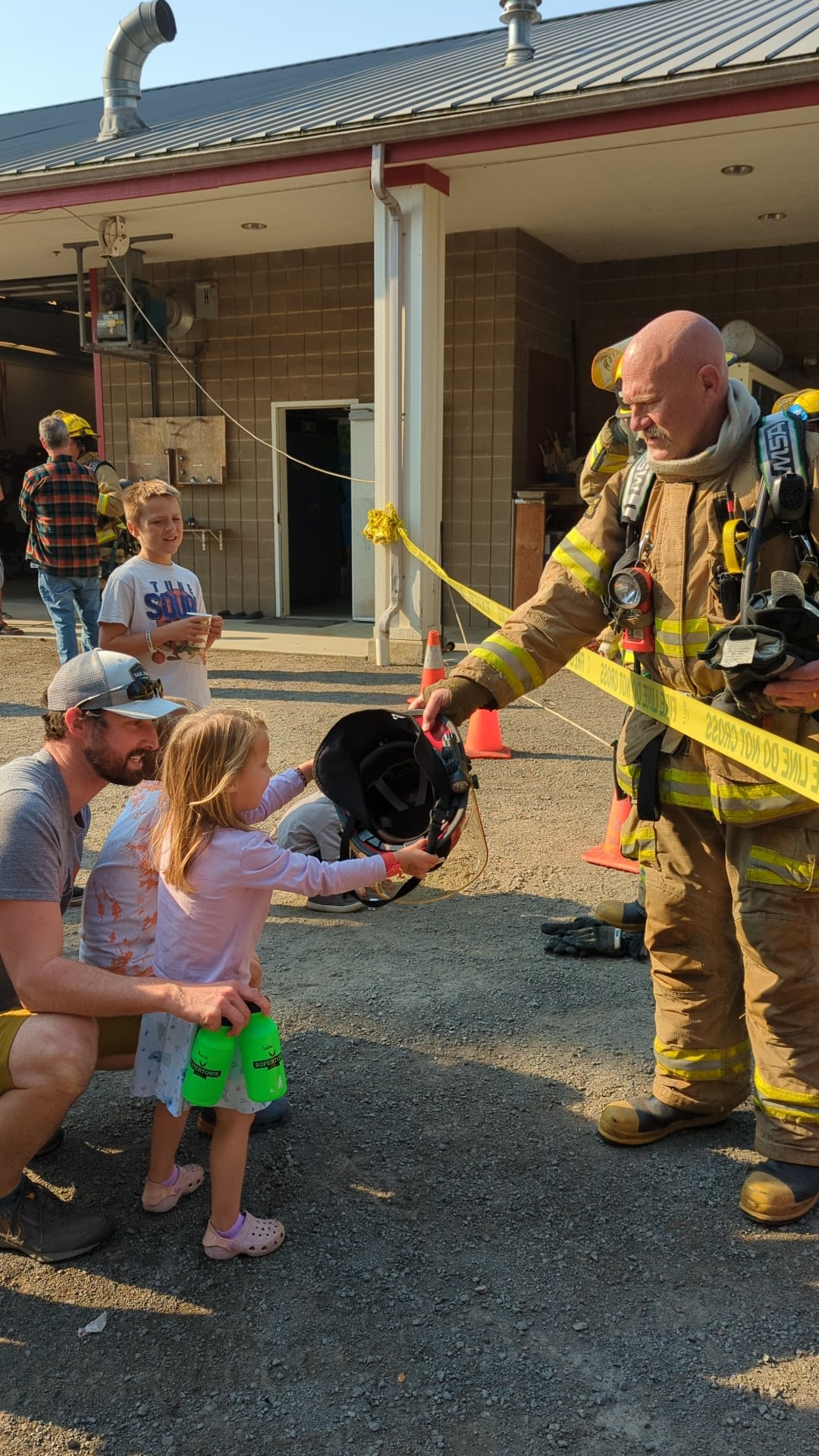 Firefighter showing equipment to a young visitor
